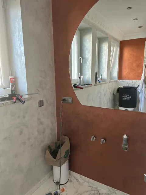 Bad mit Marmor-Optik und kupferfarbener Wand