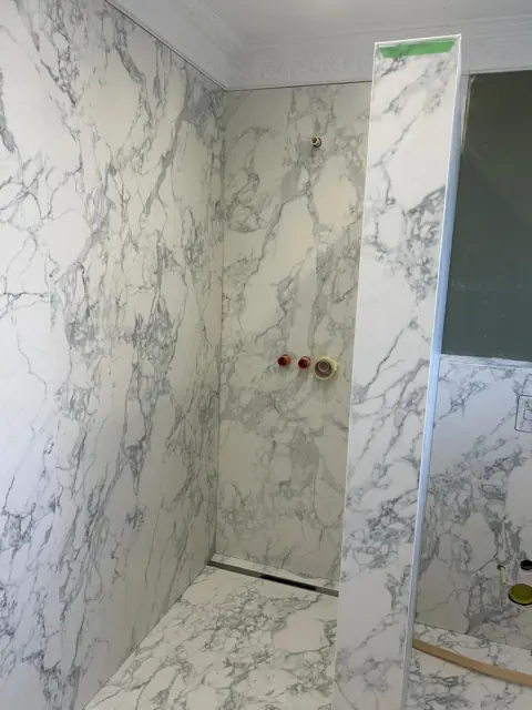 Bad in Marmor-Optik mit Vorwand und Dusche