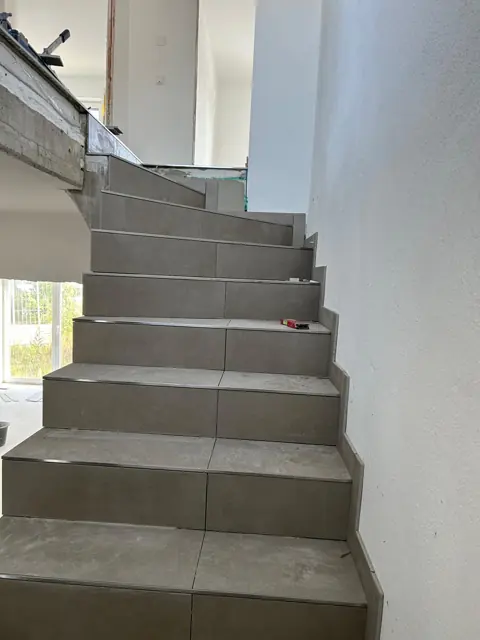 Gewendelte Treppe mit grauen Großformatfliesen
